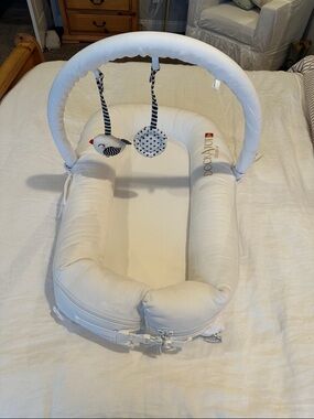 Dockatot Deluxe Plus white with toy arch Dock A Tot